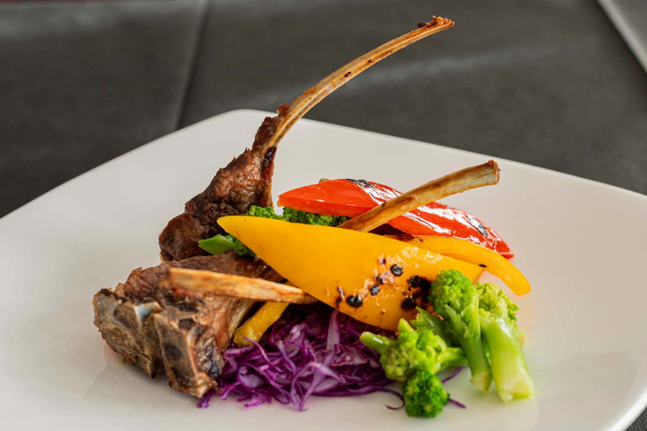Costolette d'agnello con verdure colorate e decorazioni vegetali